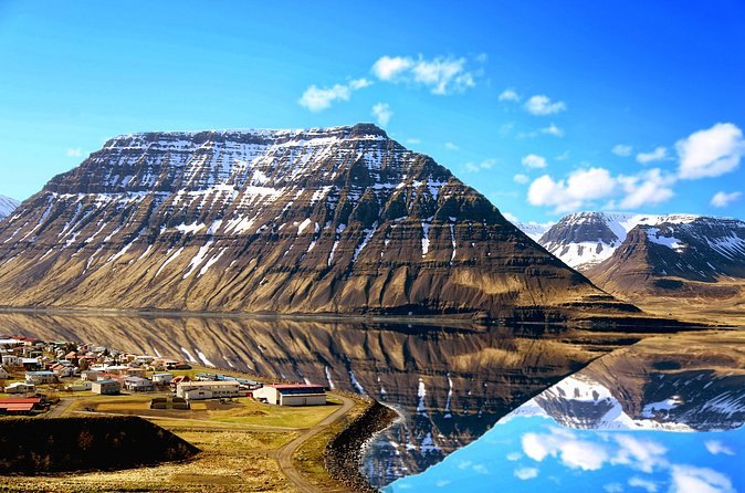 A flat-topped Westfjords mountain mirrored in still fjord water