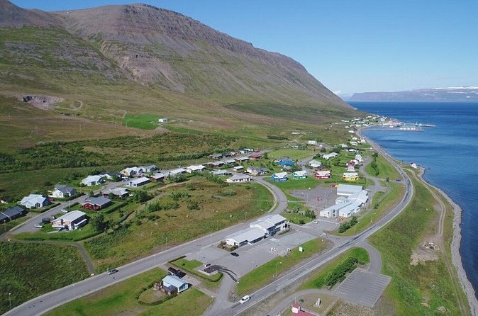 A Westfjords village strung along the shore road beneath its mountain
